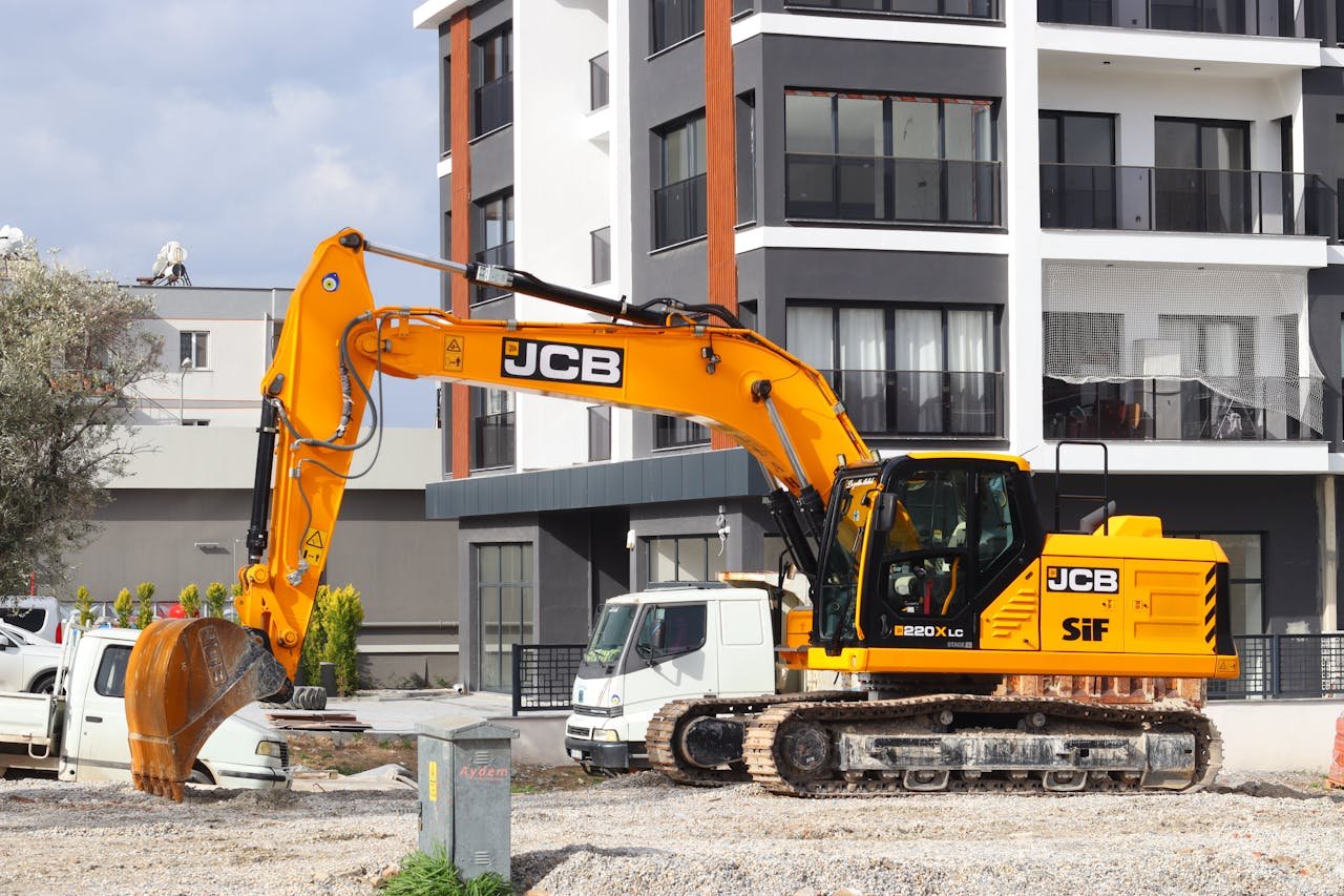The Art of Drawing Readers In: Your attractive post title goes here A yellow excavator operating at a city construction site in front of modern buildings.